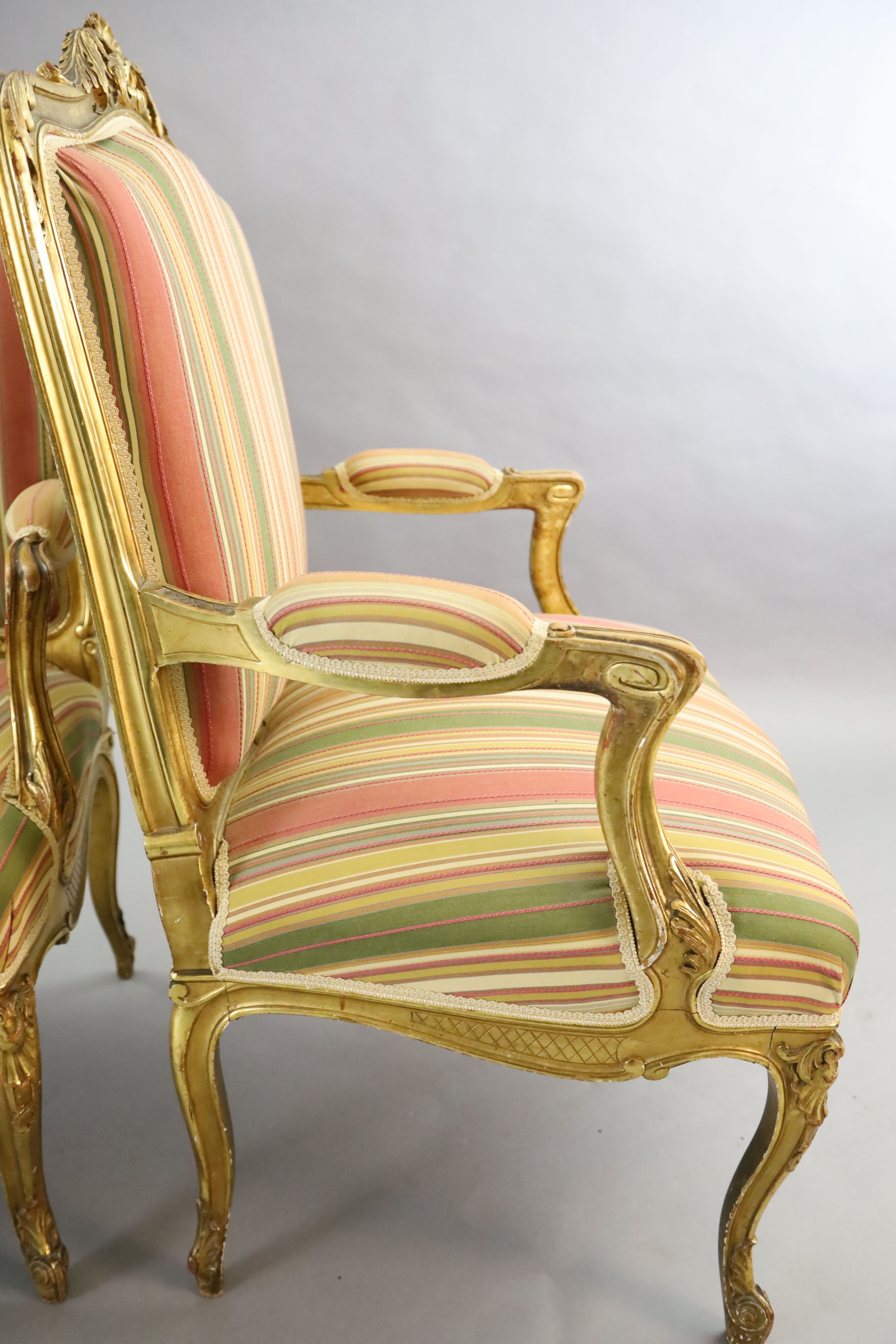 A pair of French gilt beech fauteuils, W.2ft 3in. D.2ft 1in. H.3ft 5in.